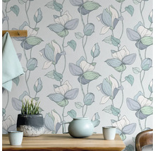 Blumentapete mit Teekanne und Topfpflanze auf Holztisch