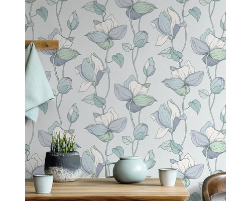 Blumentapete mit Teekanne und Topfpflanze auf Holztisch