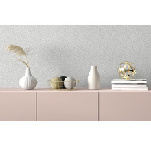 Dekorative Gegenstände auf einem Sideboard vor einer gemusterten Tapete