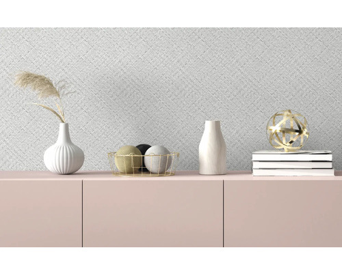 Dekorative Gegenstände auf einem Sideboard vor einer gemusterten Tapete