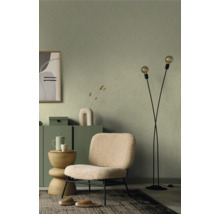 Wohnzimmer mit grüner gemusterter Tapete, Sessel, Stehlampe und Teppich