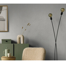 Séjour avec papier peint gris, lampadaire et meubles verts pour une ambiance chaleureuse