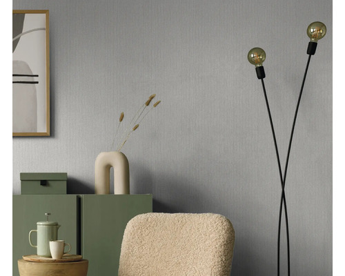 Séjour avec papier peint gris, lampadaire et meubles verts pour une ambiance chaleureuse