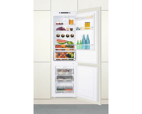 Réfrigérateur intégré ouvert avec divers aliments.