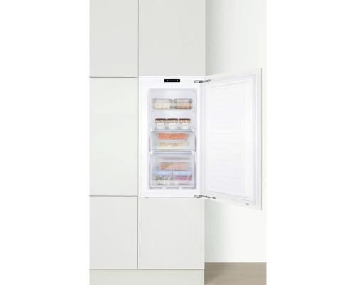 Congélateur ouvert avec des aliments dans une cuisine blanche