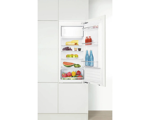 Réfrigérateur intégré avec porte ouverte, rempli d''aliments tels que du fromage, des fruits et des légumes.