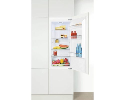 Réfrigérateur encastrable ouvert avec des aliments dans une cuisine lumineuse