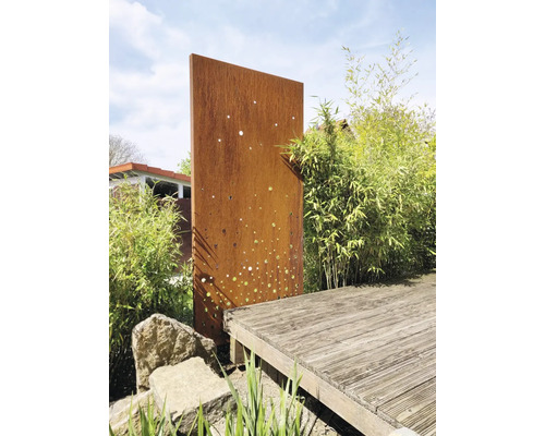 Scène de jardin avec brise-vue en métal couleur rouille et terrasse en bois