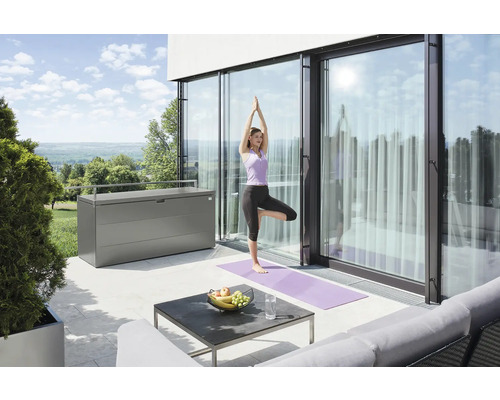Szene mit einer Frau, die Yoga auf einer Terrasse neben einer Aufbewahrungsbox praktiziert