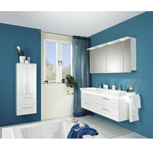 Modernes Badezimmer mit weißem Waschtisch, Spiegelschrank, Hochschrank und Badewanne vor blauer Wand