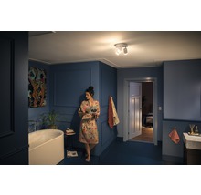 Badezimmer mit Badewanne, Waschbecken und Deckenleuchte mit drei Strahlern