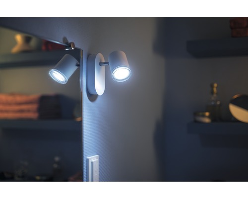 Zwei weiße LED-Wandstrahler neben einem Spiegel im Badezimmer.
