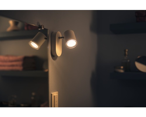 Doppelte Wandleuchte im Badezimmer mit gerichteten Lichtkegeln.