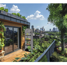 Balkon mit Gewächshaus, Pflanzen und Blick auf die Stadt.