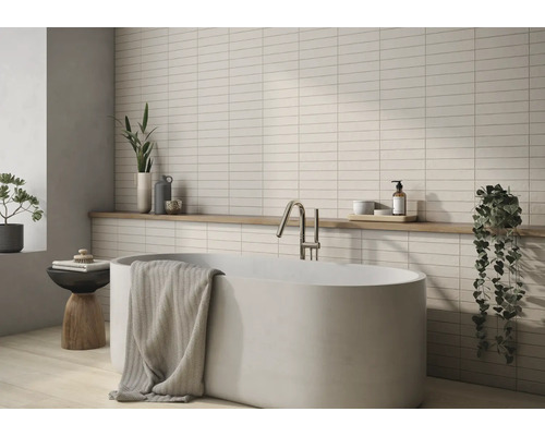 Badezimmer mit Badewanne, Armatur, Handtuch, Ablage und Wandfliesen