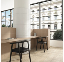 Pièce claire et organisée avec mur et sol carrelés, bureau et chaises