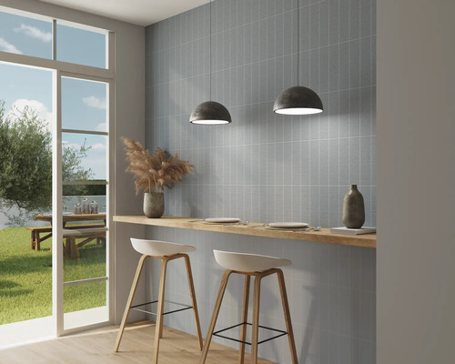 Helle Küche mit blauen Wandfliesen, Barhockern und Blick nach draußen