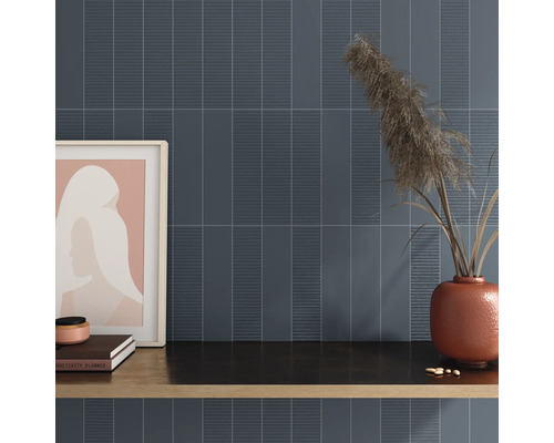 Wandgestaltung mit länglichen Fliesen und dekorativen Elementen auf einer Ablagefläche