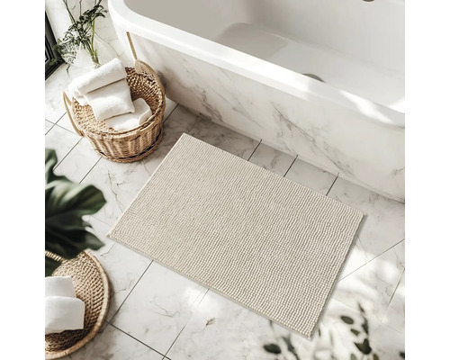 Salle de bain avec baignoire, tapis de bain et paniers avec serviettes