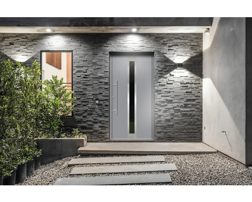 Moderne Fassade mit Haustür, Fenster und Natursteinmauerwerk sowie Beleuchtung