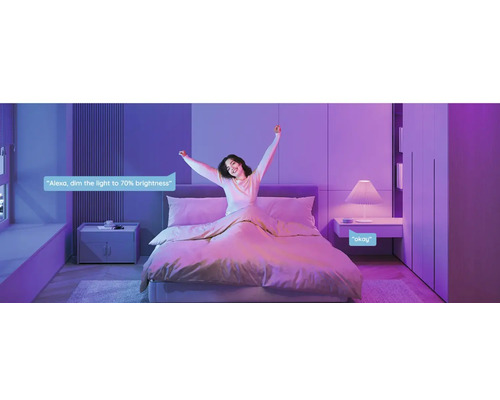 Schlafzimmer mit Bett, Nachttisch und Sprachsteuerung für smarte Beleuchtung.