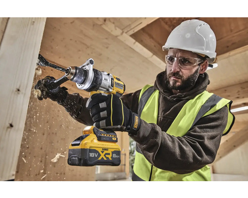 Handwerker bohrt mit einer DeWalt Akku-Bohrmaschine ein Loch in ein Holzbrett