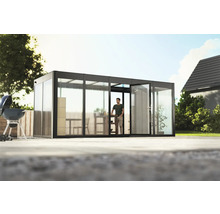 Pavillon de jardin avec portes coulissantes en verre et une personne à l''intérieur, entouré d''un jardin