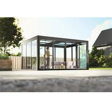 Freistehender Glasgarten mit Schiebetürsystem und sitzendem Mann auf Terrasse