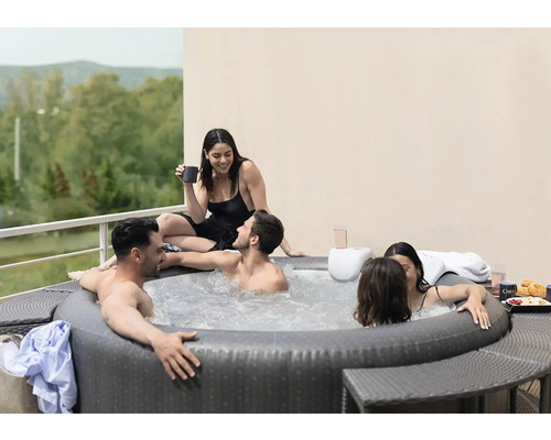 Jacuzzi gonflable avec plusieurs personnes à l''extérieur sur une terrasse.