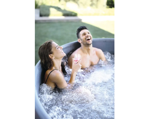 Deux personnes se détendent en riant dans un bain nordique dans le jardin