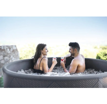 Couple se détendant avec des boissons dans le bain à remous