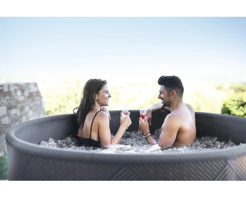 Couple se détendant avec des boissons dans le bain à remous