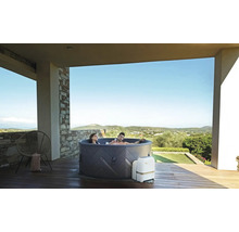 Bain à remous gonflable avec deux personnes sur une terrasse avec vue