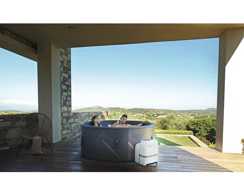Bain à remous gonflable avec deux personnes sur une terrasse avec vue