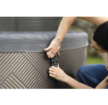 Personne fixant le couvercle d''un spa avec des boucles