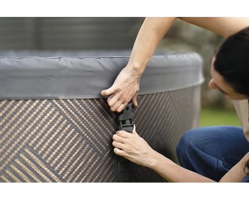 Personne fixant le couvercle d''un spa avec des boucles