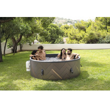 Jacuzzi gonflable avec quatre personnes dans le jardin.