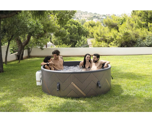 Jacuzzi gonflable avec quatre personnes dans le jardin.