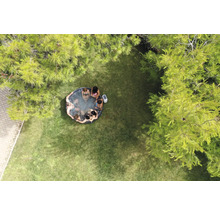 Vue aérienne d''un jardin avec un jacuzzi gonflable dans lequel plusieurs personnes sont assises.