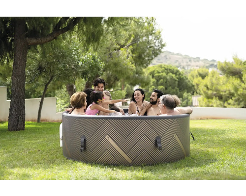 Une famille se détend dans un jacuzzi gonflable dans le jardin.