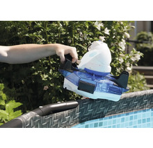 Une main place un nettoyeur de piscine sur le bord d''une piscine.