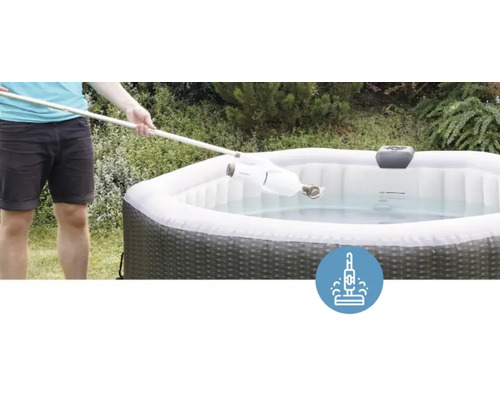 Une personne nettoie un bain à remous gonflable avec un aspirateur