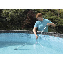 Mann reinigt Pool mit Poolreiniger und Stange