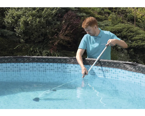 Mann reinigt Pool mit Poolreiniger und Stange