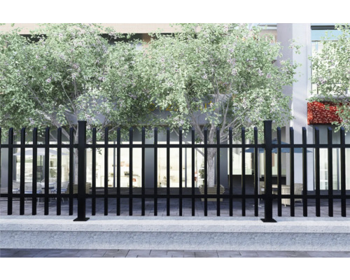 Schwarzer Metallzaun vor einem Gebäude mit Bäumen