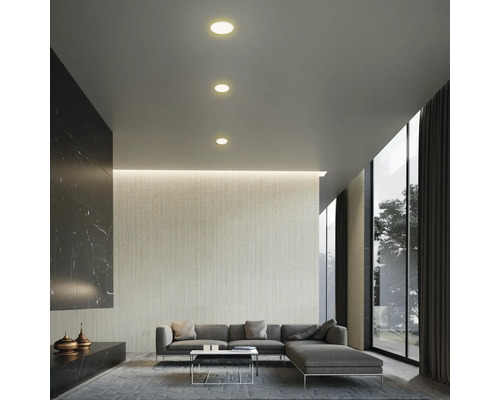 Salon lumineux avec canapé gris, tapis et plafonniers