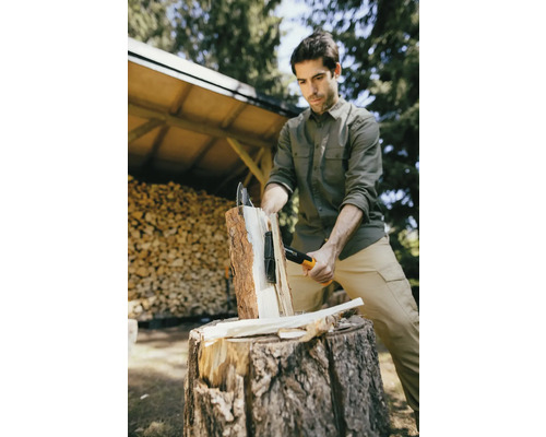 Homme fendant du bois avec une hache à fendre sur un billot à l''extérieur.