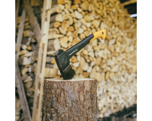 Spalthammer auf einem Baumstumpf vor einem Holzstapel