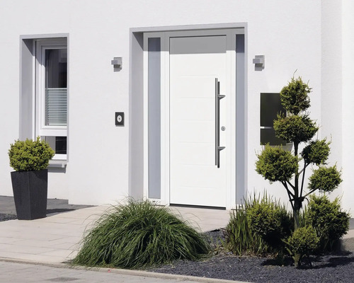 Extérieur d''une maison avec porte d''entrée blanche et plantes
