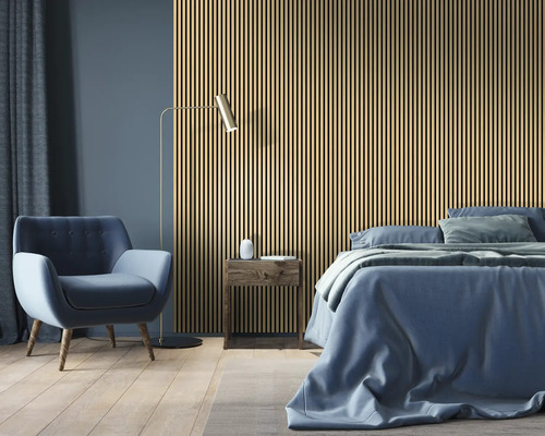Schlafzimmer mit Akustikpaneelen, Bett, Sessel und Stehlampe